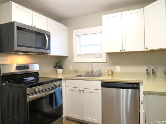 kitchen with stainless steel appliances, light countertops, and white cabinetry