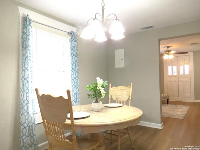 dining area featuring ceiling fan with notable chandelier, dark wood-style flooring, visible vents, and baseboards