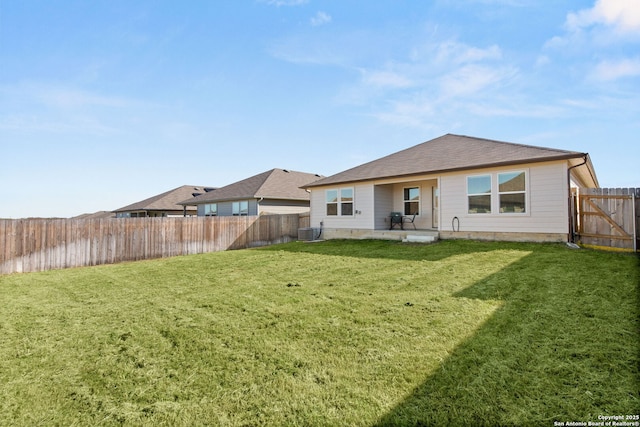 back of house featuring cooling unit, a patio area, a fenced backyard, and a yard