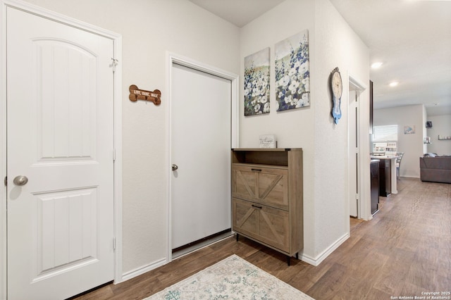 hallway with dark wood-style floors and baseboards