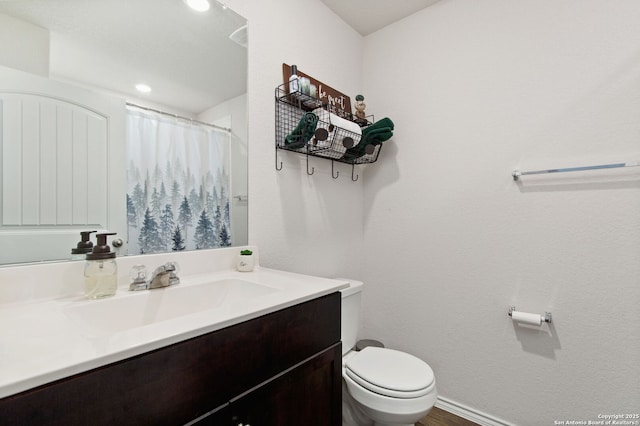 full bath featuring a shower with curtain, vanity, toilet, and baseboards