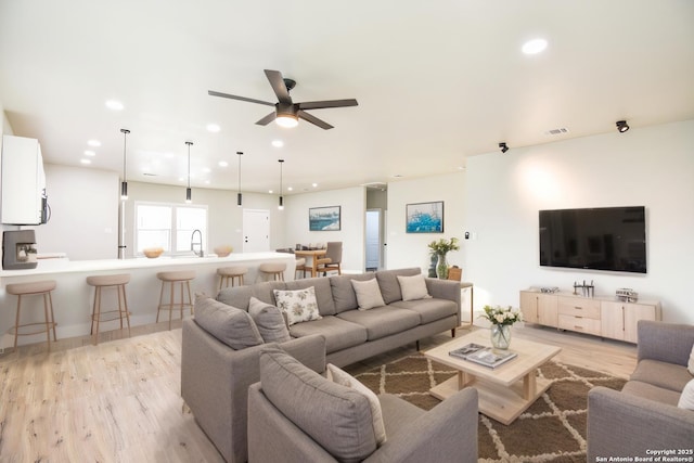 living room with light wood-style flooring, visible vents, a ceiling fan, and recessed lighting