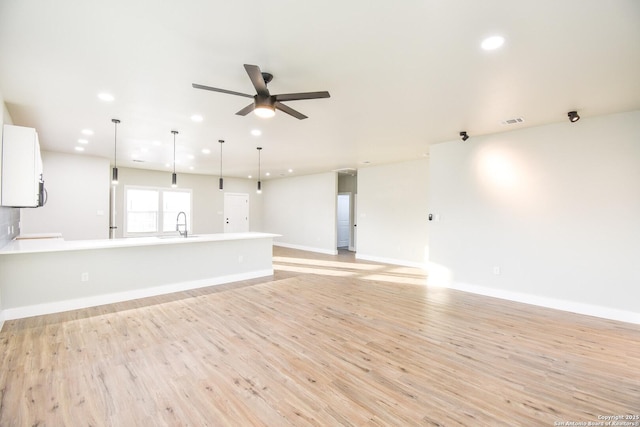 unfurnished living room with light wood-style flooring, visible vents, a ceiling fan, and recessed lighting