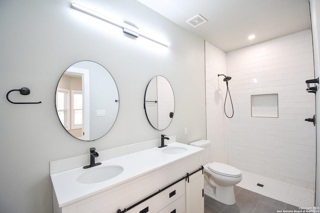 bathroom with toilet, a sink, visible vents, and tile patterned floors