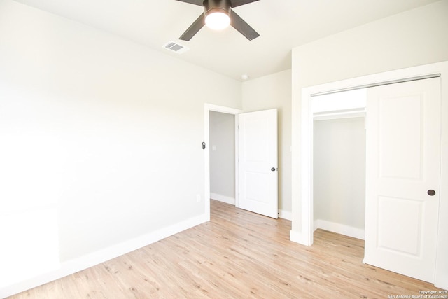 unfurnished bedroom featuring visible vents, baseboards, light wood-style flooring, ceiling fan, and a closet