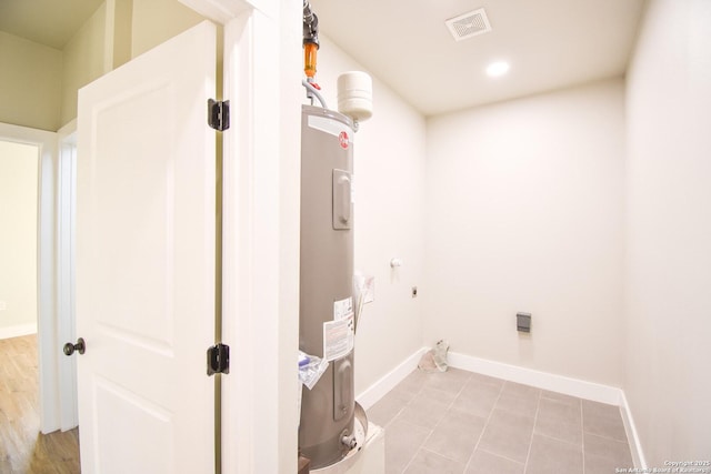 washroom with laundry area, visible vents, baseboards, electric water heater, and recessed lighting