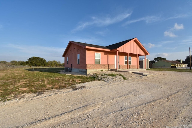 view of front of property with cooling unit and board and batten siding