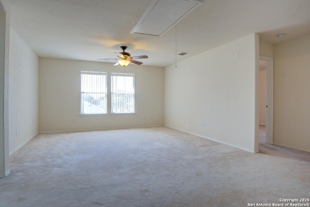 unfurnished room featuring visible vents, baseboards, attic access, and light colored carpet