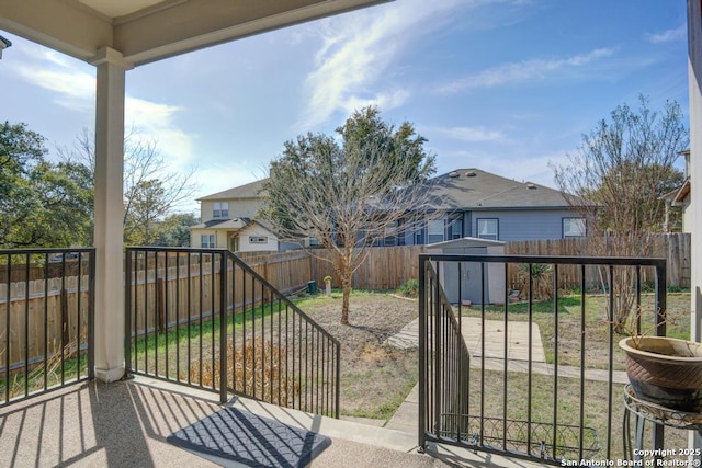 exterior space featuring a residential view, a fenced backyard, an outbuilding, and a storage unit
