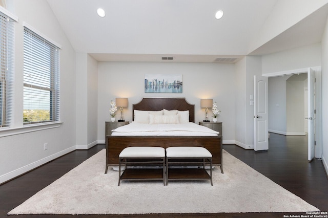 bedroom featuring vaulted ceiling, dark wood finished floors, and visible vents