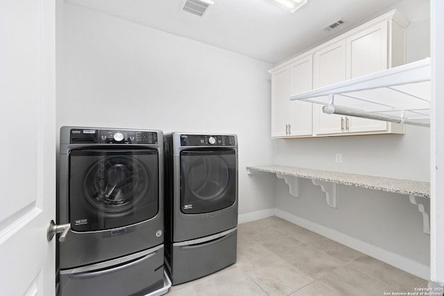 laundry area with light tile patterned flooring, independent washer and dryer, visible vents, and baseboards