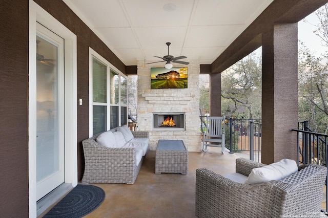 view of patio / terrace featuring a ceiling fan and an outdoor living space with a fireplace