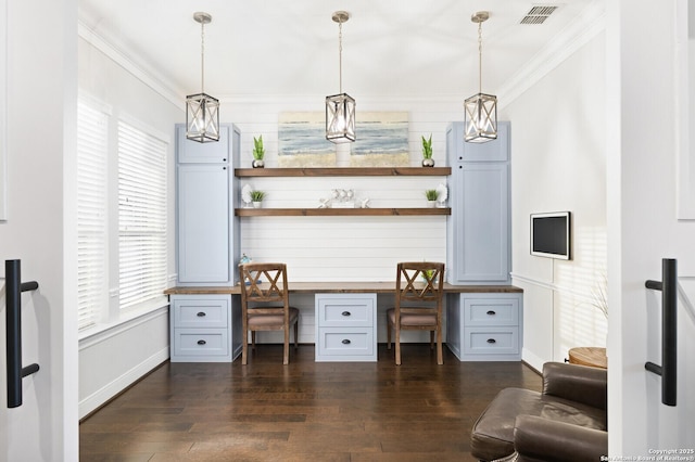 home office with ornamental molding, visible vents, dark wood finished floors, and built in desk