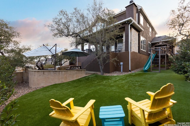 yard at dusk featuring a playground