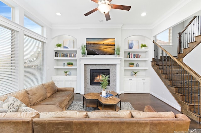 living area featuring dark wood-style floors, a wealth of natural light, and crown molding