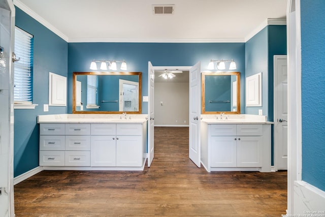 full bath featuring crown molding, visible vents, a sink, and wood finished floors