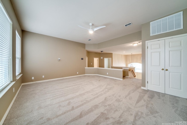 spare room with baseboards, visible vents, and light colored carpet