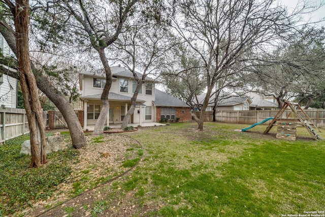 view of yard featuring a fenced backyard and a playground