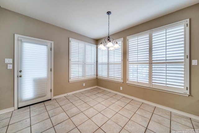 unfurnished dining area featuring light tile patterned floors, baseboards, and a chandelier