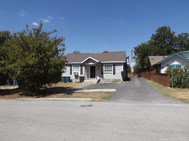 bungalow-style house with aphalt driveway and fence