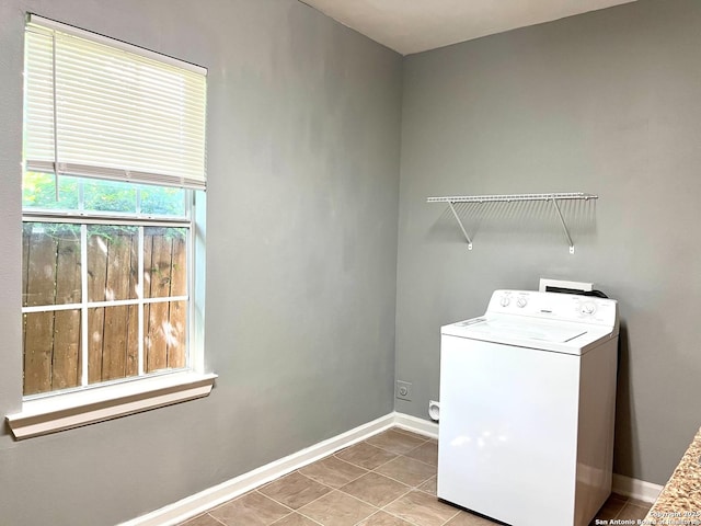 washroom featuring light tile patterned floors, laundry area, washer / dryer, and baseboards