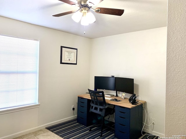 office area with baseboards, a ceiling fan, and tile patterned floors