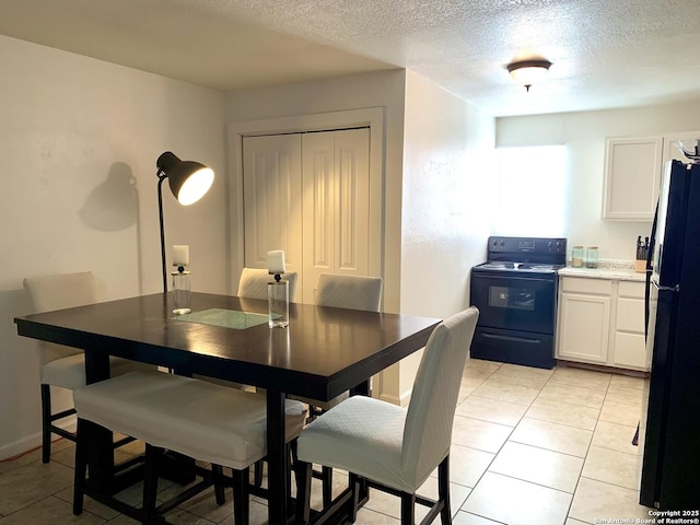 dining area featuring a textured ceiling and light tile patterned flooring