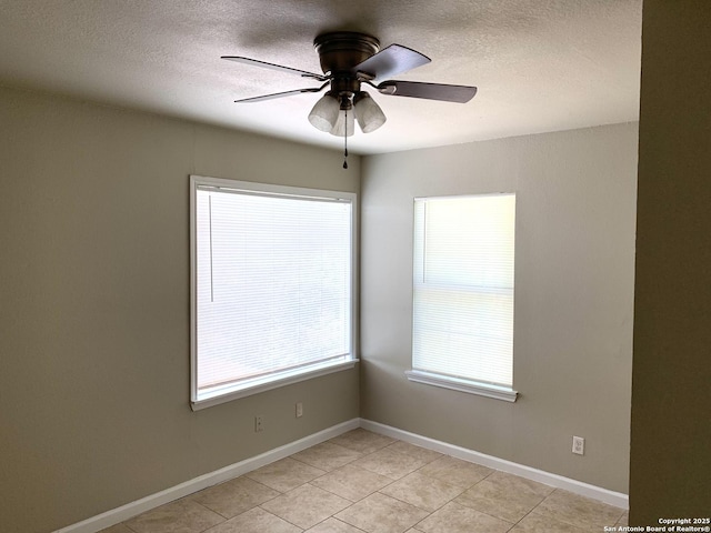 unfurnished room featuring ceiling fan, a textured ceiling, baseboards, and light tile patterned floors