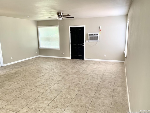 unfurnished room with a wall unit AC, baseboards, and a ceiling fan