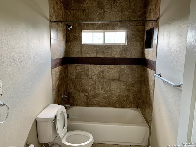 bathroom featuring washtub / shower combination and toilet