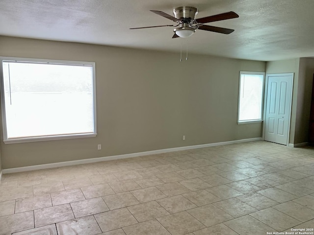 unfurnished room featuring a ceiling fan, baseboards, and a textured ceiling