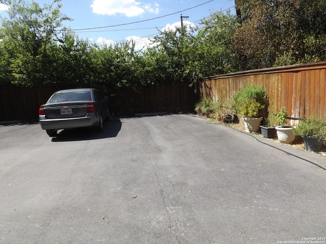 view of vehicle parking featuring fence