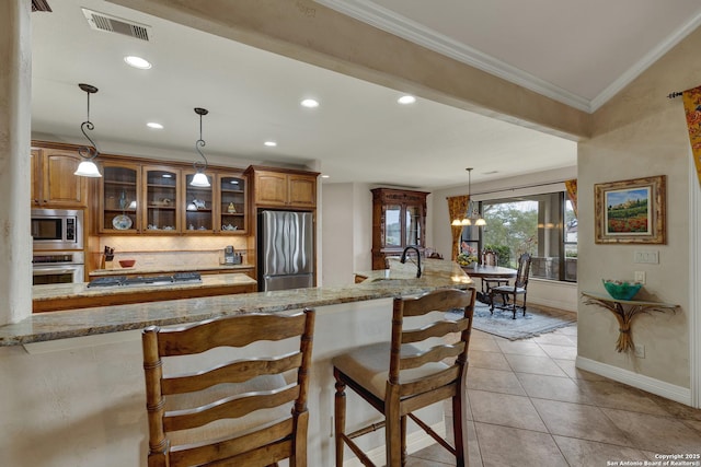 kitchen featuring light tile patterned floors, visible vents, brown cabinets, stainless steel appliances, and crown molding