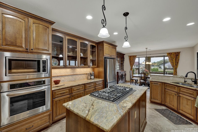 kitchen with tasteful backsplash, glass insert cabinets, light stone countertops, stainless steel appliances, and a sink