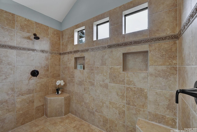 full bathroom featuring lofted ceiling and tiled shower