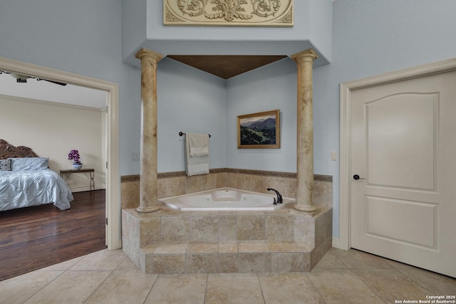 ensuite bathroom featuring ornate columns, tile patterned flooring, a garden tub, and ensuite bathroom