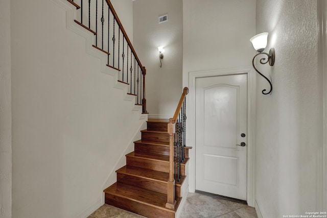 stairs with baseboards and visible vents