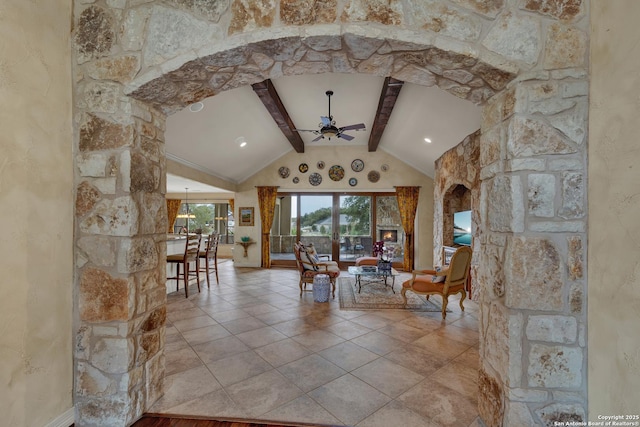 interior space with vaulted ceiling with beams, arched walkways, a ceiling fan, and tile patterned floors