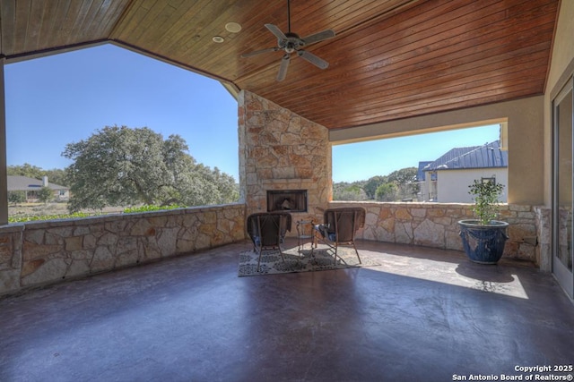 view of patio / terrace featuring an outdoor stone fireplace and ceiling fan