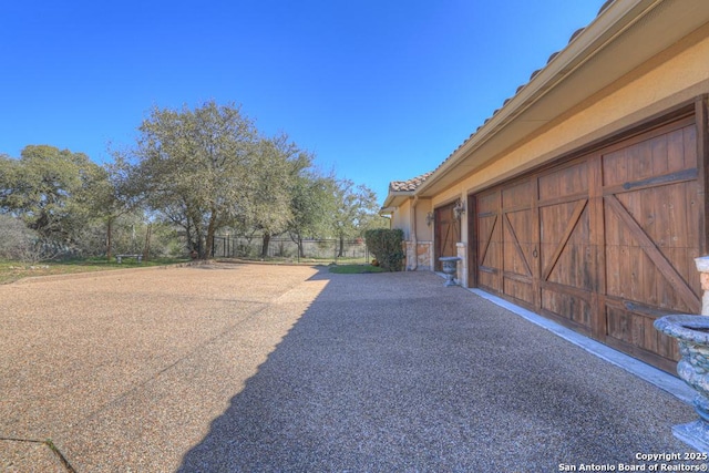 exterior space featuring a garage and fence