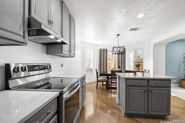 kitchen featuring stainless steel range with electric stovetop, gray cabinets, and under cabinet range hood