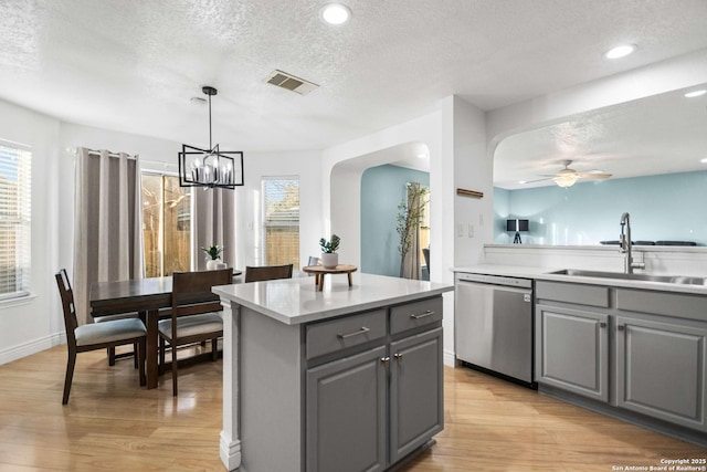 kitchen featuring a center island, gray cabinets, light countertops, visible vents, and stainless steel dishwasher