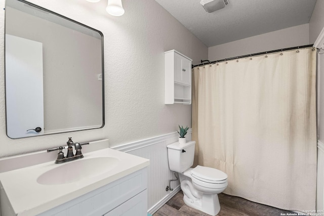 full bath with visible vents, toilet, wood finished floors, a textured ceiling, and vanity