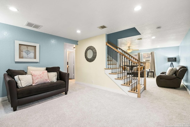 living room featuring light colored carpet, visible vents, baseboards, and stairs