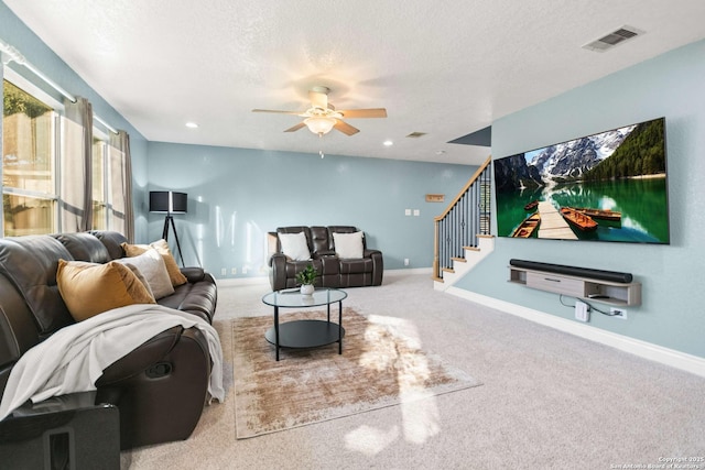 living room featuring baseboards, visible vents, stairway, and a textured ceiling