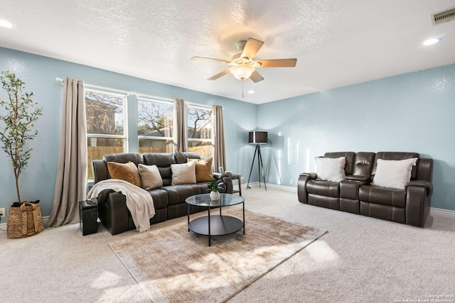 living area with visible vents, ceiling fan, a textured ceiling, and baseboards