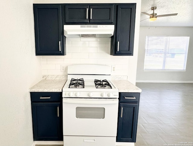 kitchen featuring under cabinet range hood, tasteful backsplash, white range with gas stovetop, and light countertops