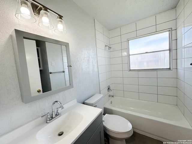 bathroom featuring a textured ceiling, a textured wall, toilet, vanity, and  shower combination