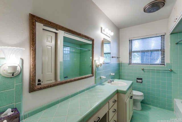 full bath featuring a wainscoted wall, tile walls, toilet, vanity, and tile patterned flooring