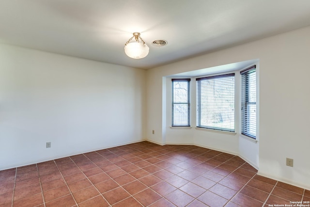 tiled spare room with visible vents